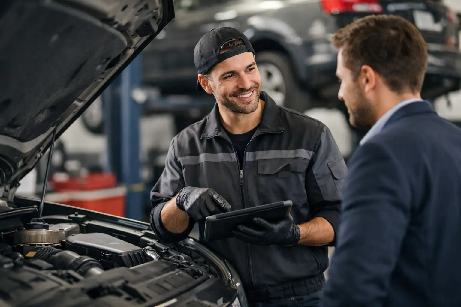 Freelance automonteur in gesprek met een klant in de werkplaats